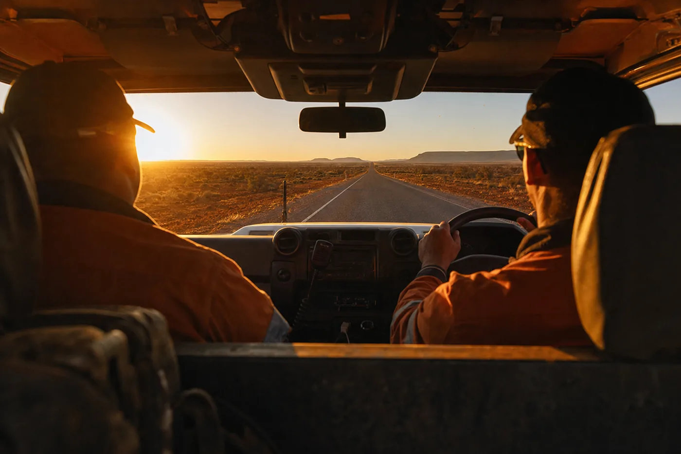 Two hotshot drivers in the cab looking out the windscreen at a Pilbara sunrise on a non-stop 2UP run, Western Australia